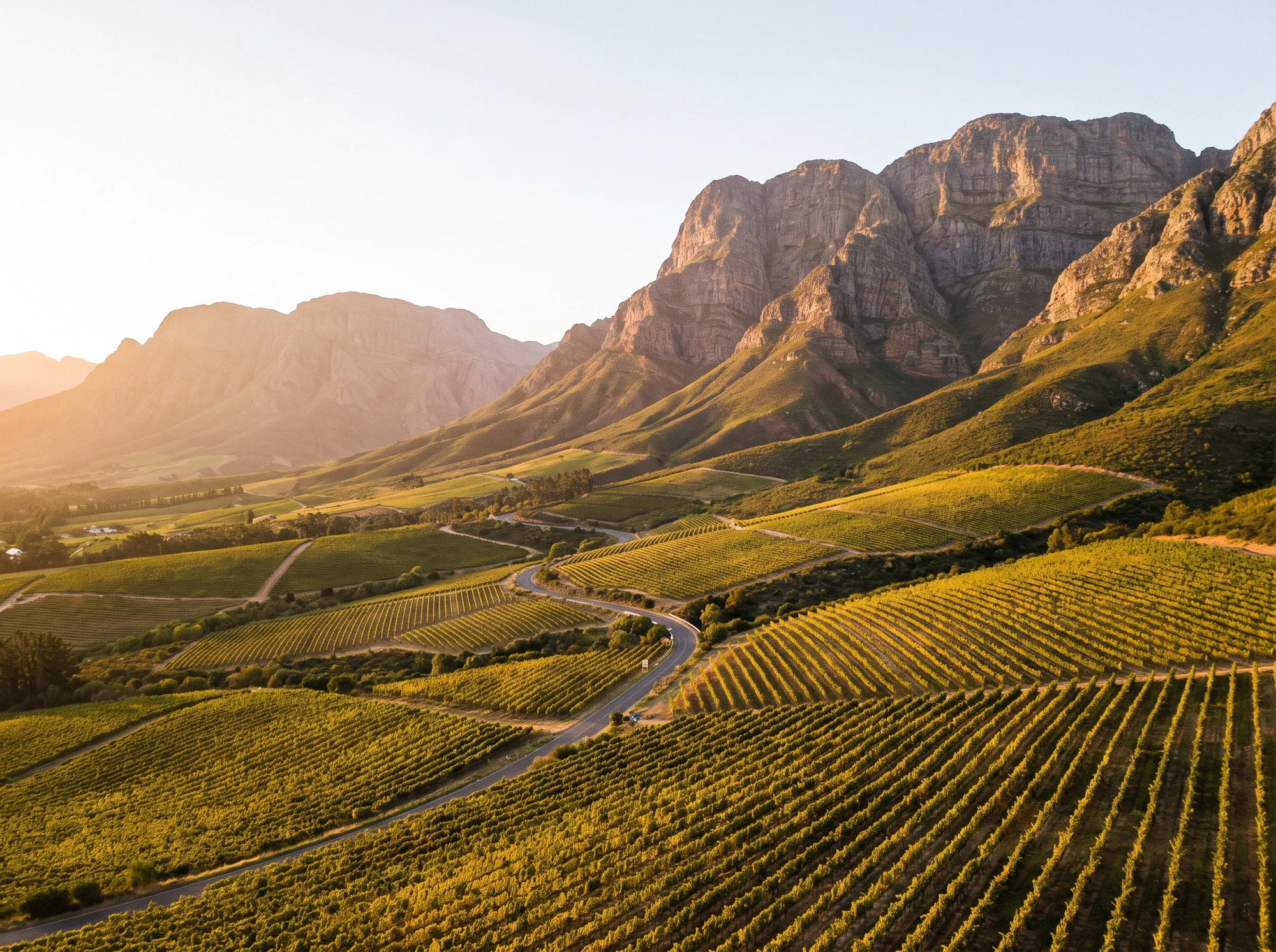 Winding valley road through vineyards toward a gap in the mountains on the way to Franschhoek from Simondium